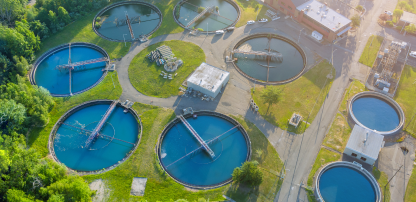 An image of a water treatment plant with multiple circular clarifiers.