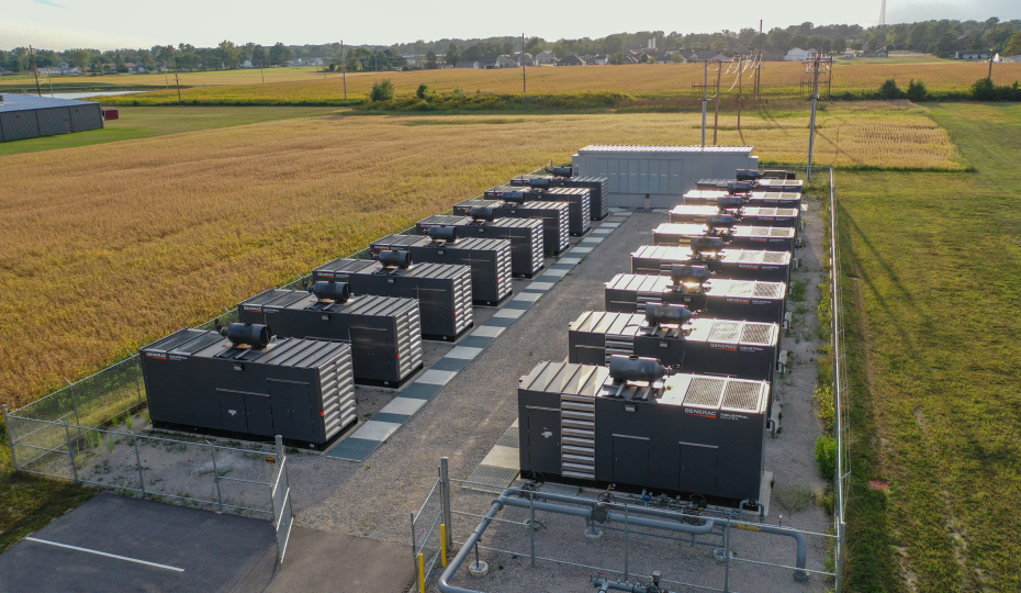 a row of Generac industrial generators in a field