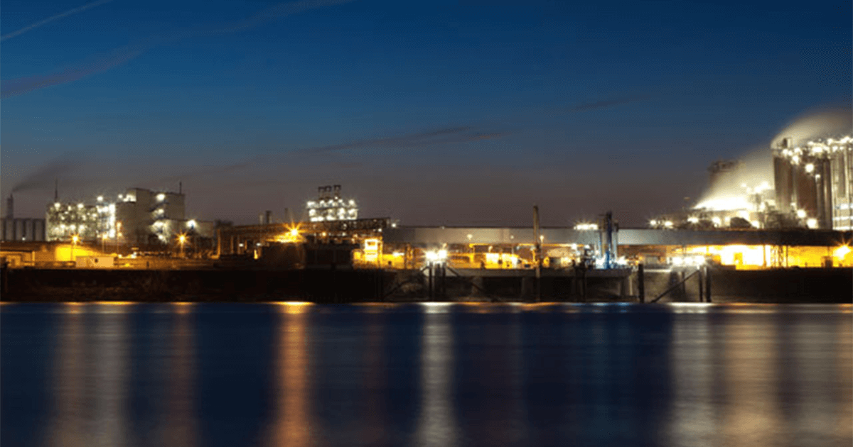 Manufacturing buildings at night on the river.