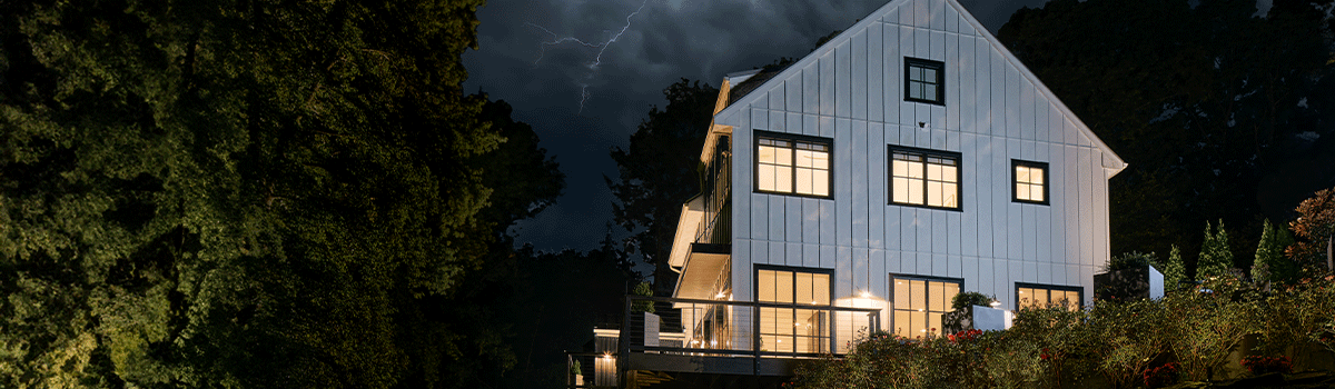Image of house in a storm with lights on