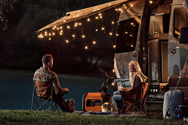 couple using portable inverter generator while camping in a van