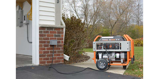 Generac portable generator on sidewalk near garage outside of home.