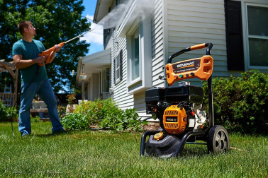 A man using his Generac Power Washer outside on a sunny day.