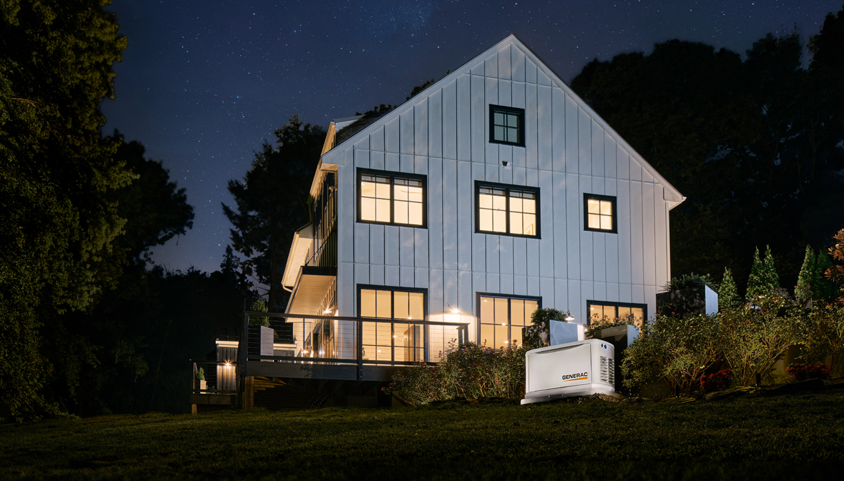 Generac home standby generator outside a home with lights on