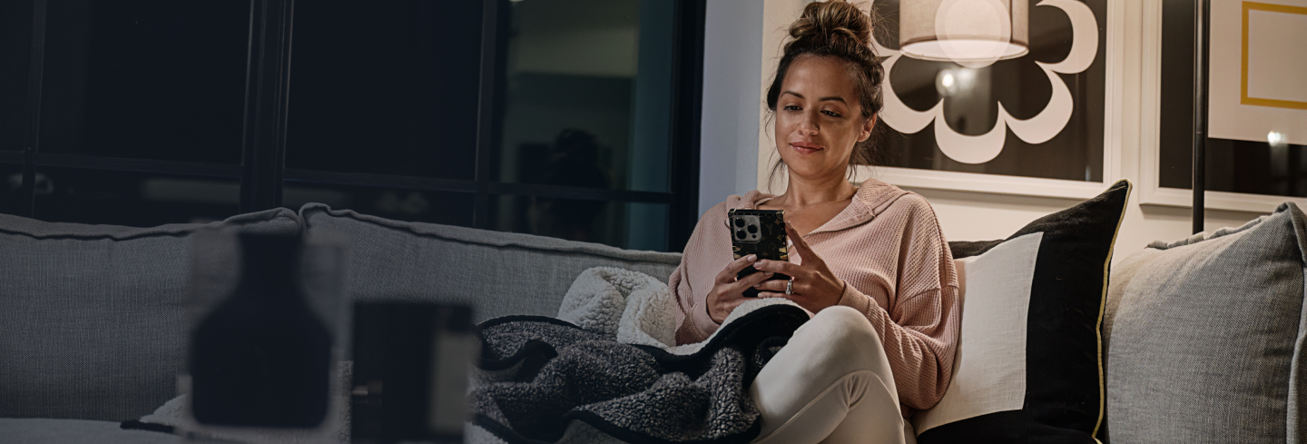 Woman looking at phone on living room couch