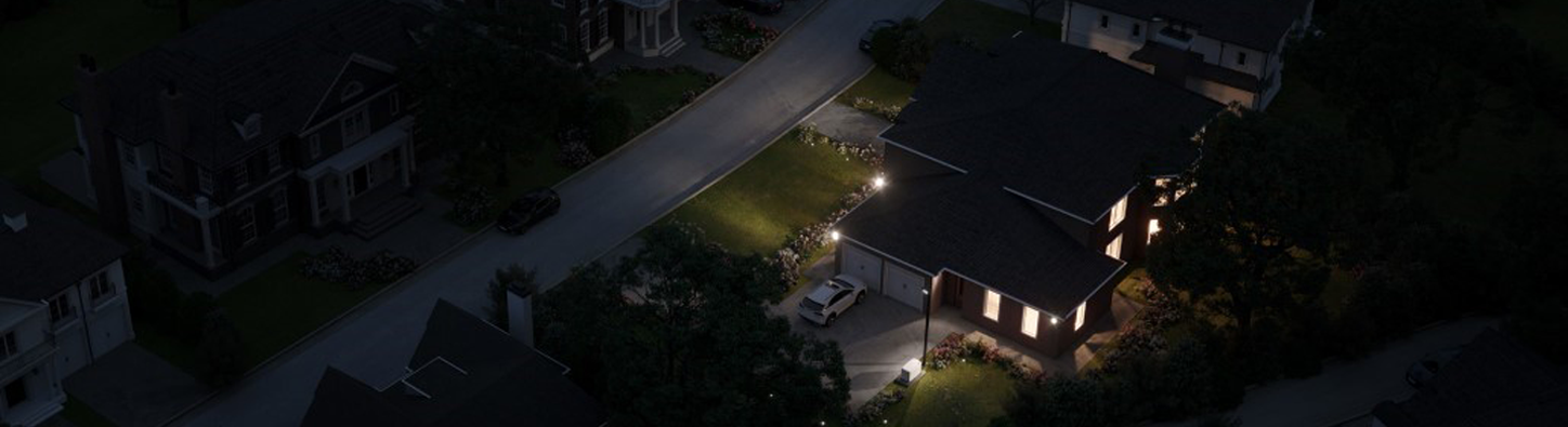 An aerial view of a house on the right with lights on at night