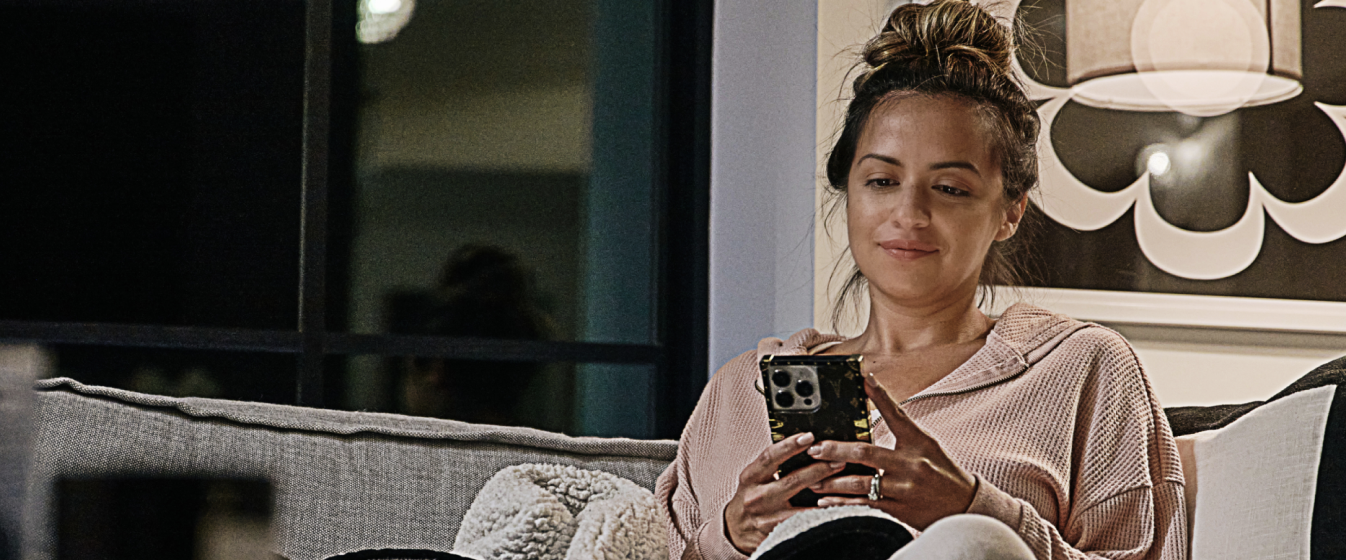 Woman sitting on couch looking at cell phone